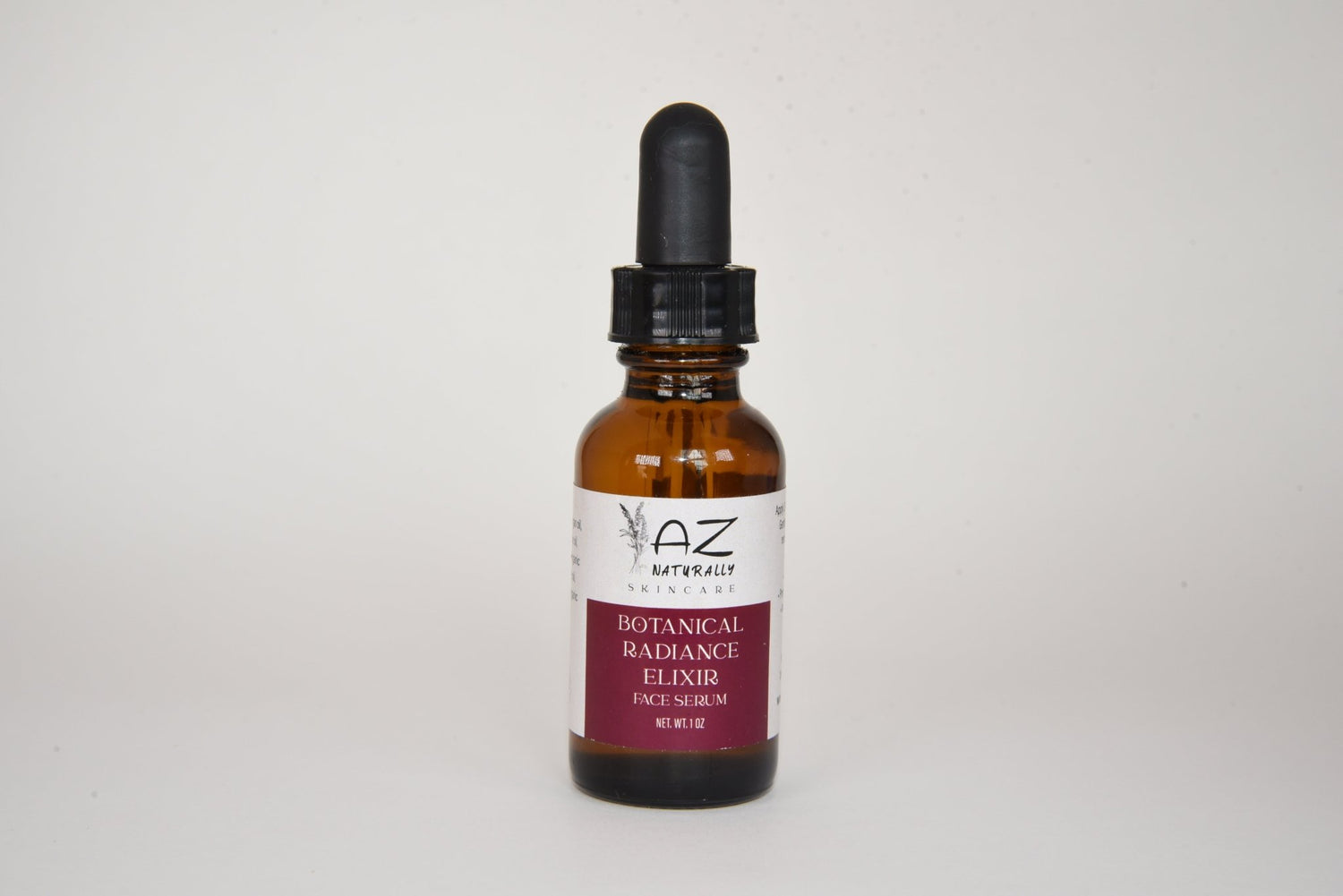 Amber dropper bottle of 'Botanical Radiance Elixir - Face Serum' on a light gray background
