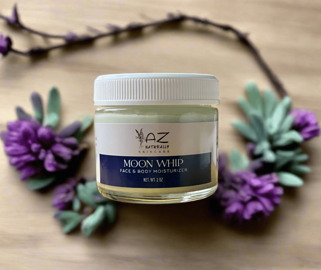 Jar of 'Moon Whip' face and body moisturizer with lavender flowers on a wooden surface