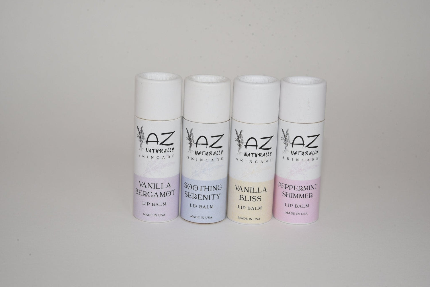 Four bottles of 'Natural Lip Balm' labeled 'Vanilla Bergamot', 'Soothing Serenity', 'Vanilla Bliss', and 'Peppermint Shimmer'