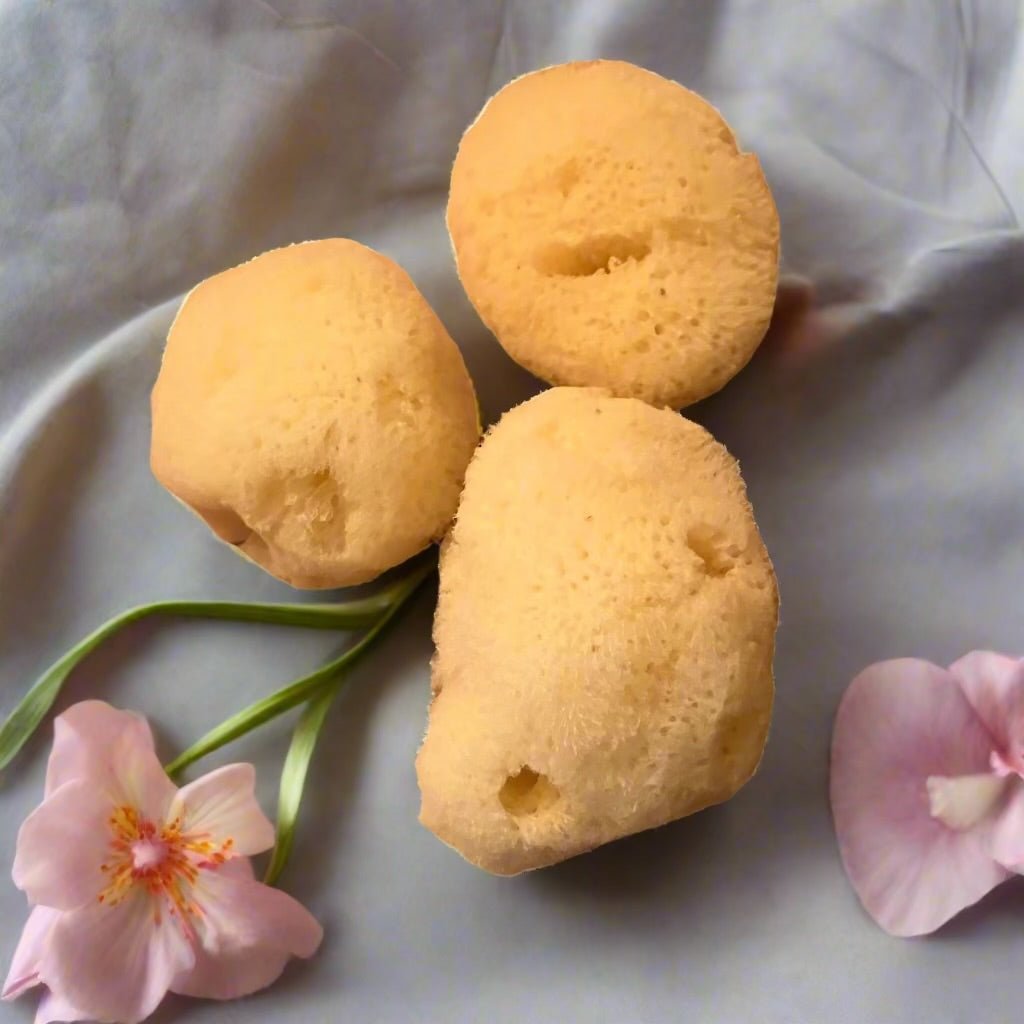'Natural Silk Facial Sponges' with white flowers on a silk background